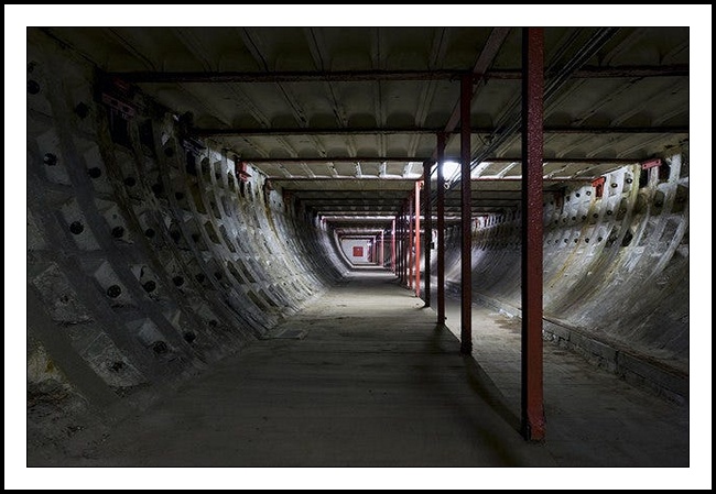 A photograph of underground walkway through Clapham North station. The cladding of the tunnel is identical to that seen for train track use.